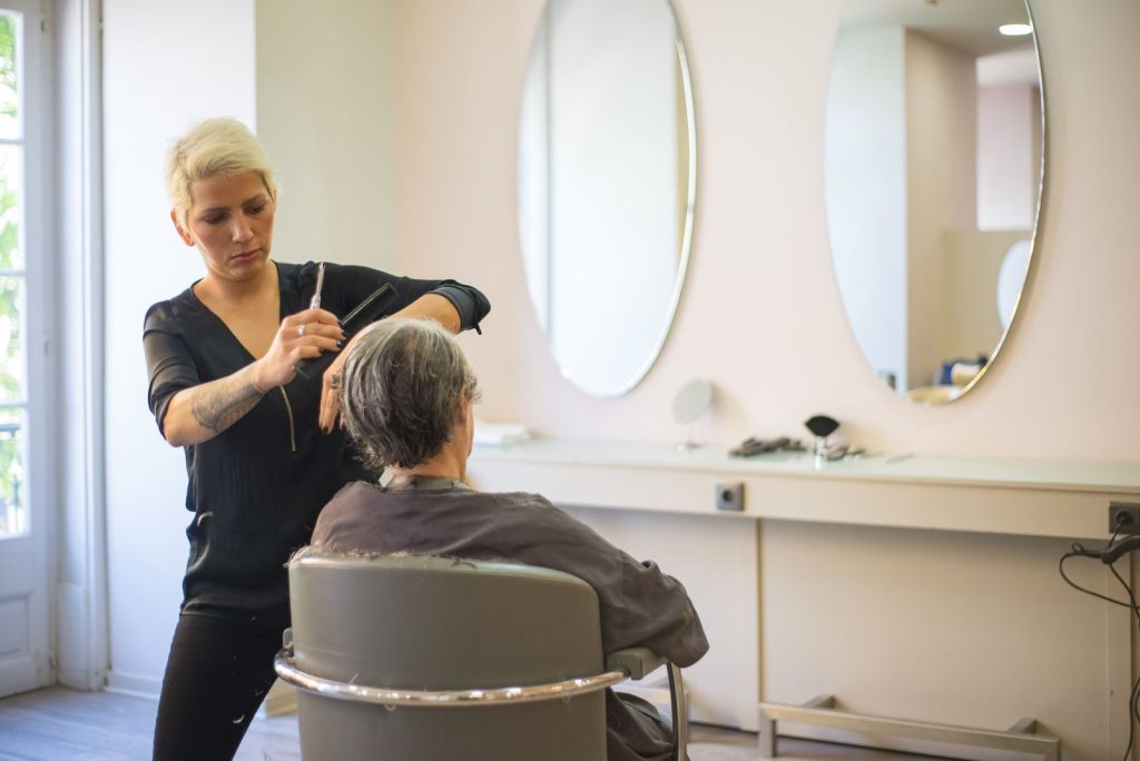 Friseurin schneidet einer Kundin professionell die Haare